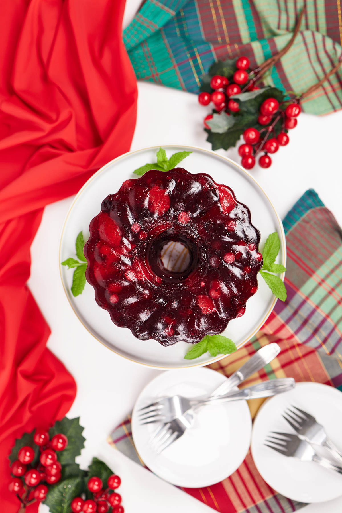 Holiday table with Christmas ornaments and cherry jello as the centerpiece.