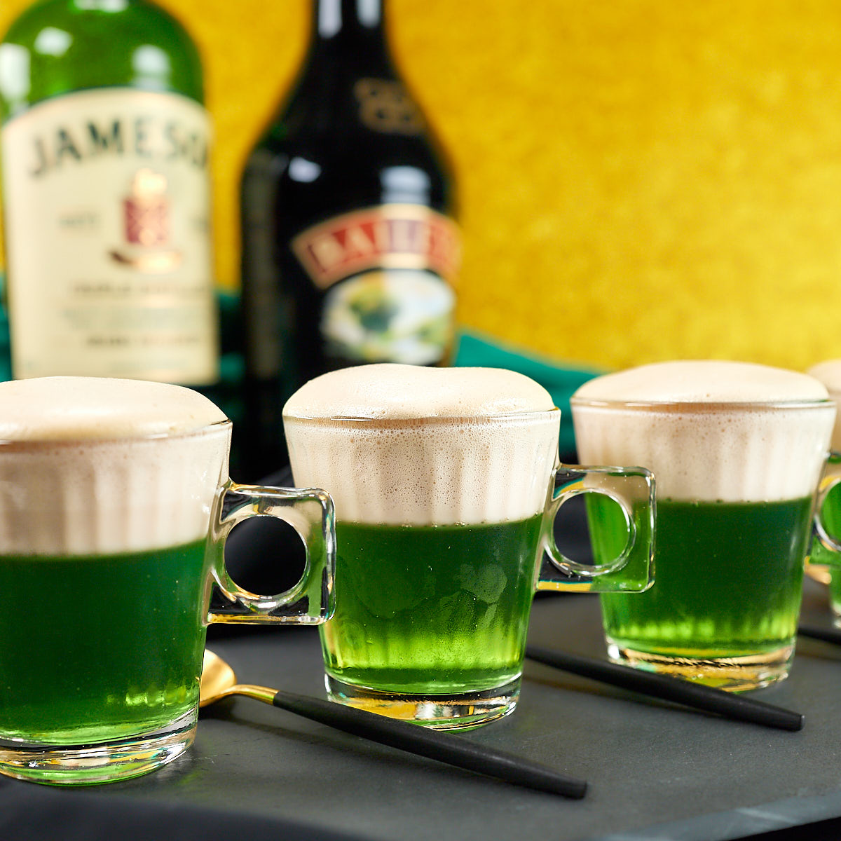 Baileys and Jameson green jello shots in baby beer glass mugs.