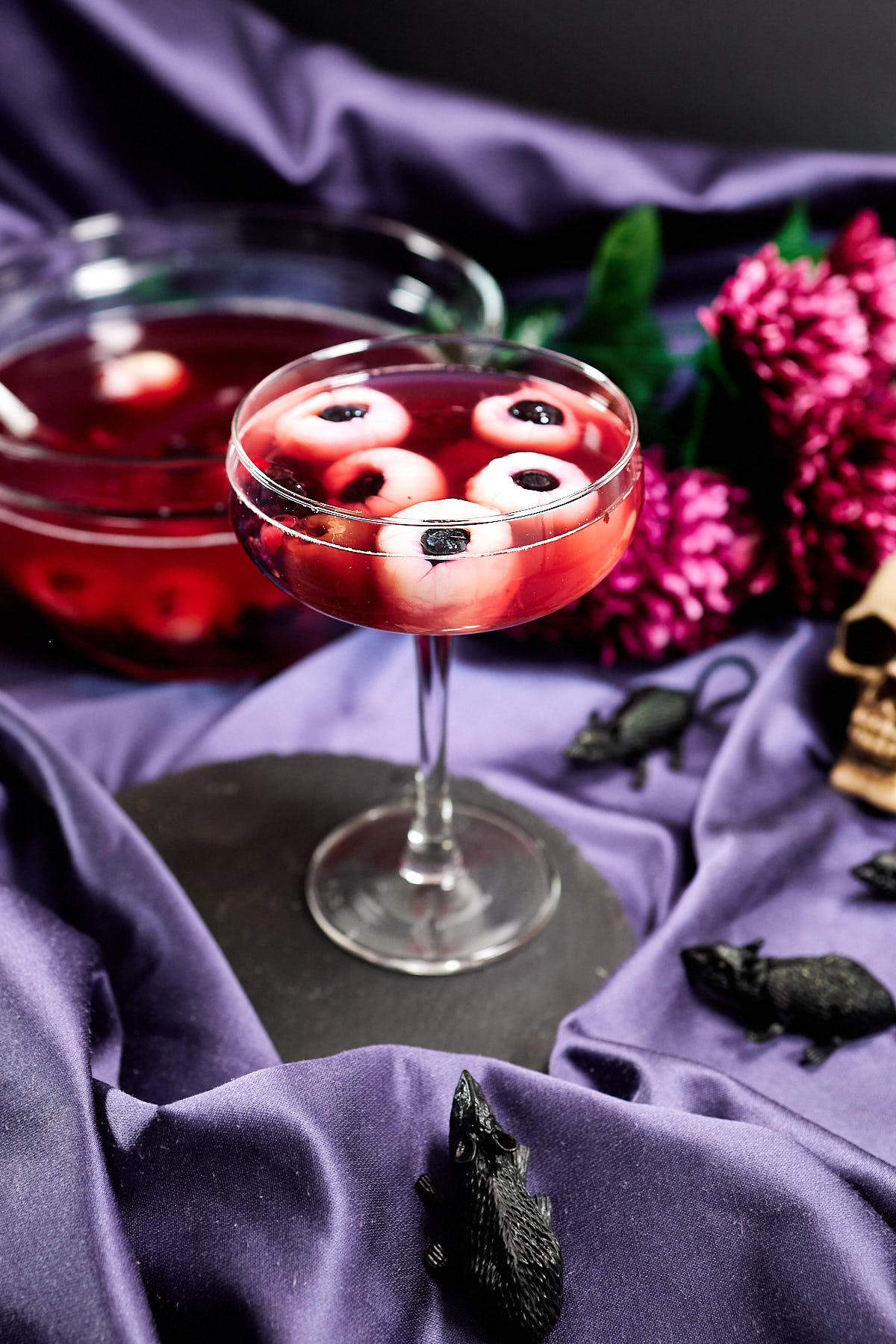 An elegant stemmed glass with spiked punch and floating eyeballs.