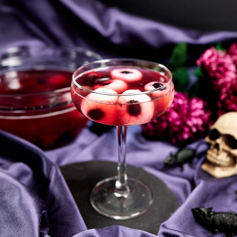 A tall cocktail glass with Halloween eyeball punch.