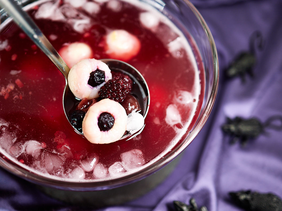 Serving Halloween punch with eyeballs with a laddle.