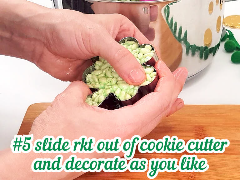 Pressing rice krispies treat out of cookie cutter with fingers.