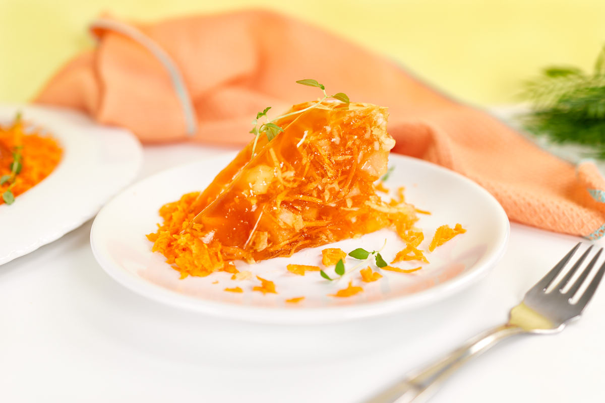 Slice of carrot and pineapple orange jello salad.