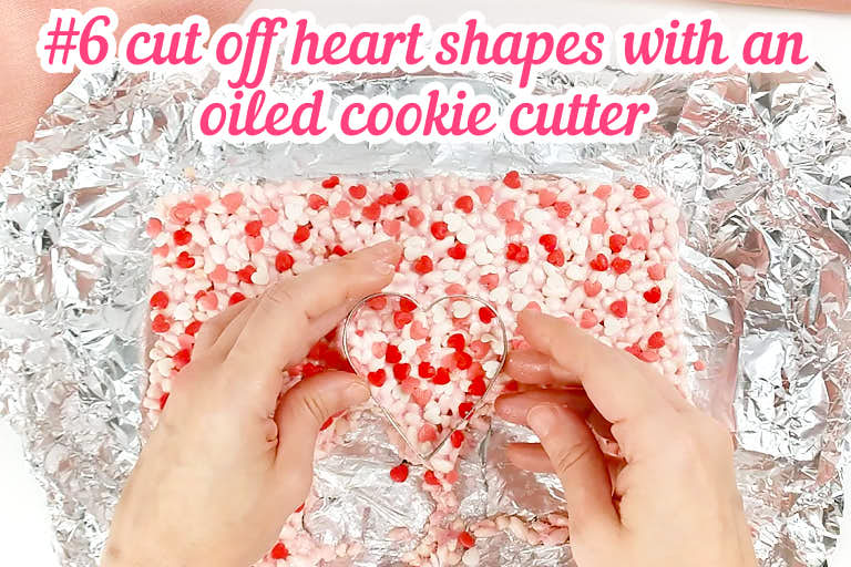 Cutting rice krispies treats with heart-shaped cookie cutter.